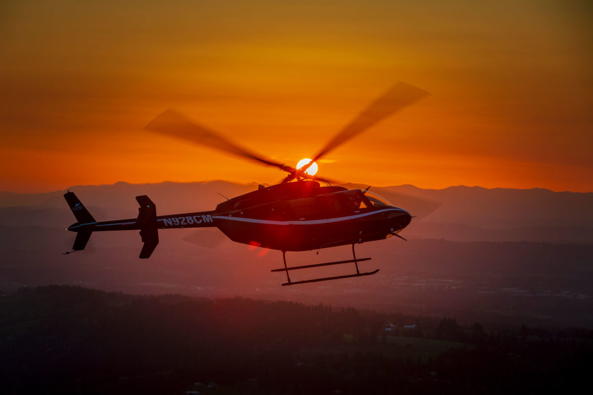 helicopter flying across sunset