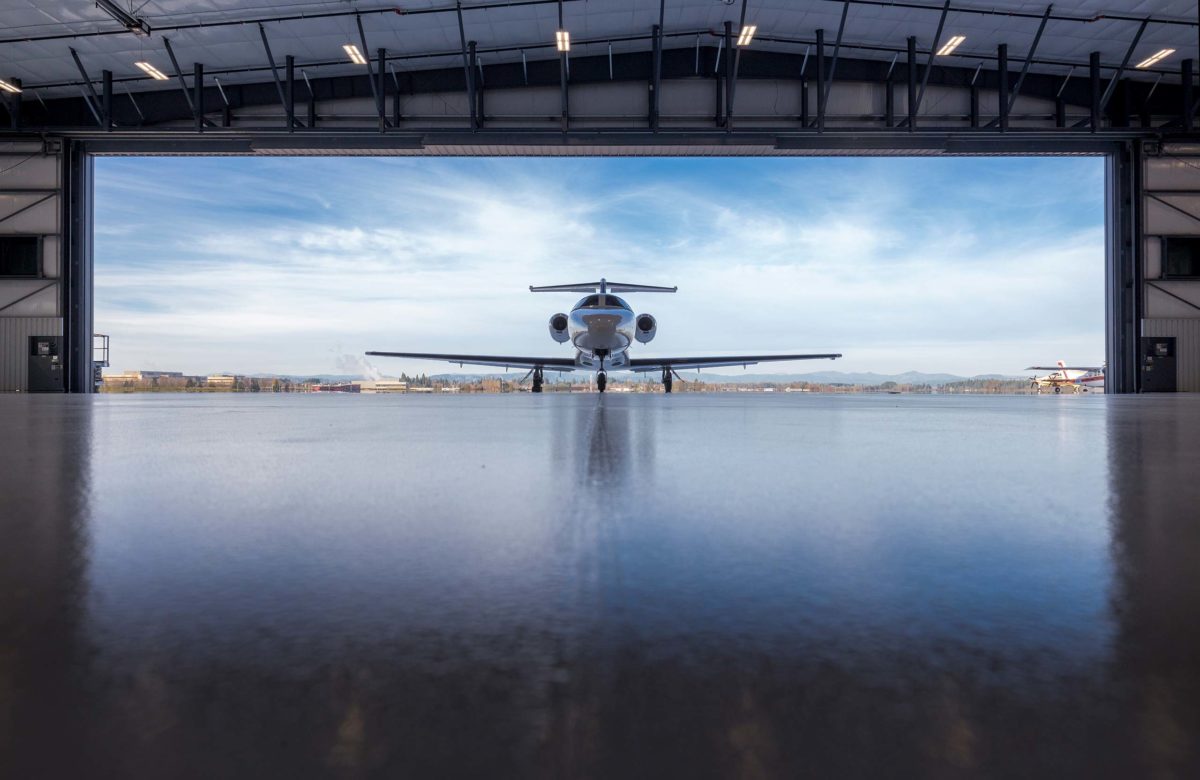 airplane coming into hanger with sky background